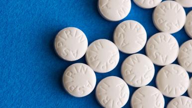 Multiple aspirin tablets on a blue background