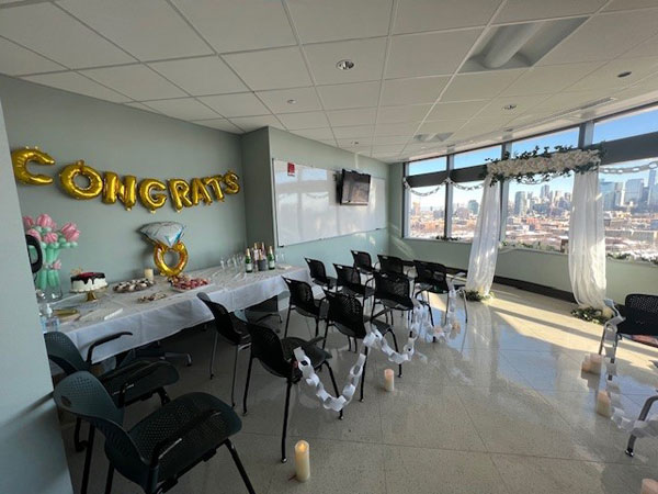 A conference room was transformed into a beautiful chapel with row seating and a makeshift altar at the front, backdropped by floor-to-ceiling windows overlooking the Chicago skyline.