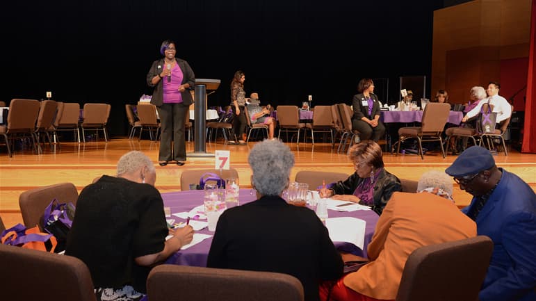 Charlene Gamboa, PhD, legal liaison for the RUSH Office of Research Affairs, speaks to study participants at the Crystal Celebration of the Minority Aging Research Study in 2019.