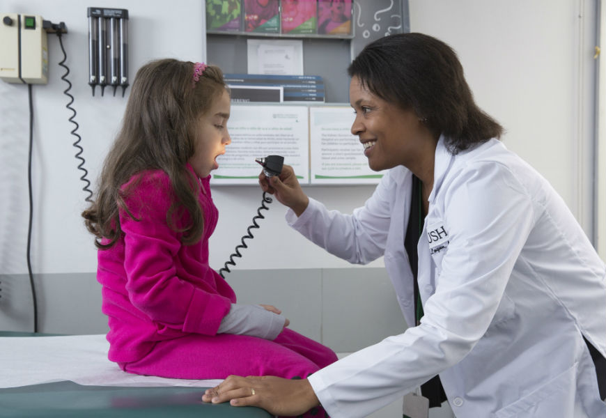 doctor checking little girls throat