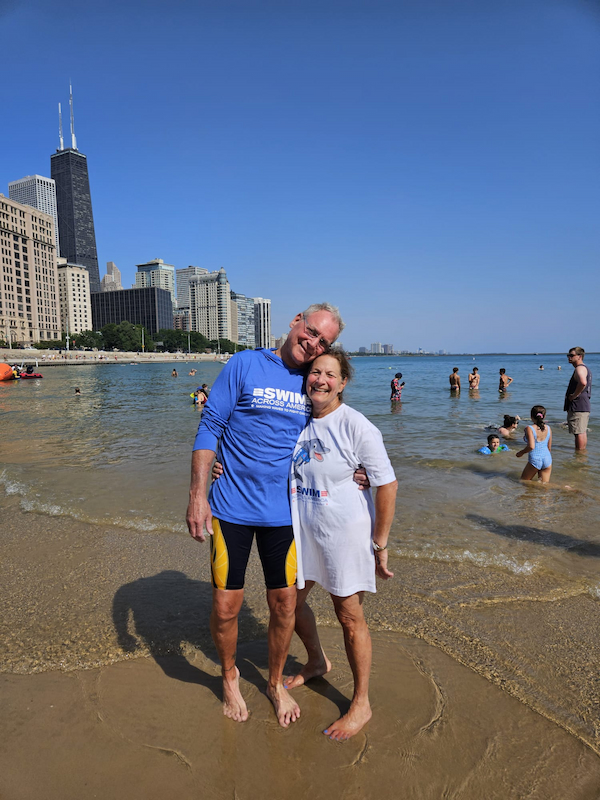 Tom Boucher and Melinda Remaly stand on Ohio Street Beach for a previous Swim Across America Chicago Open Water Swim.