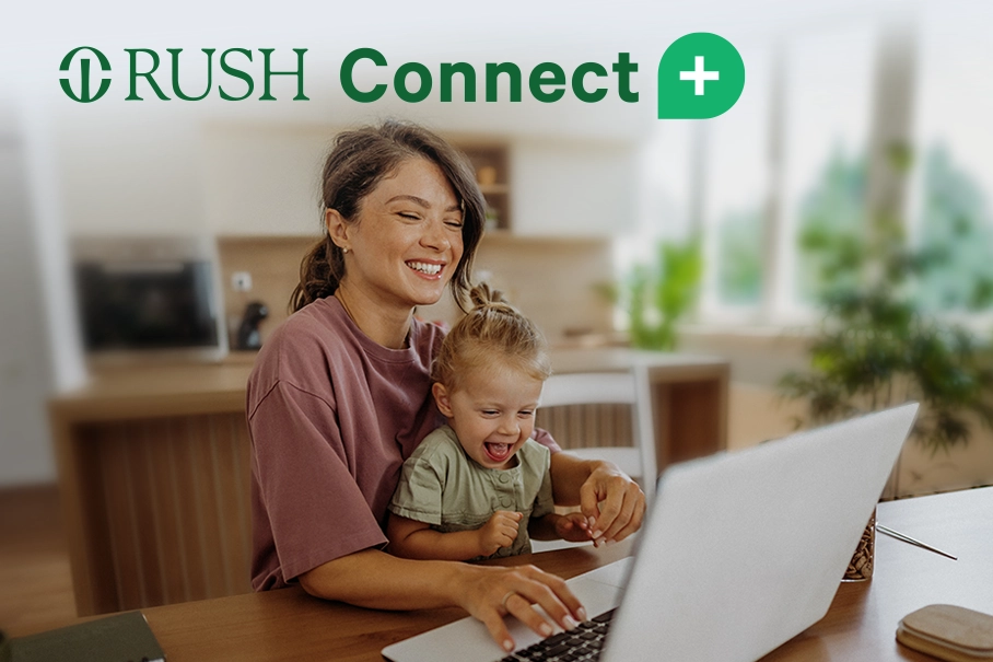 A woman using a laptop with her child