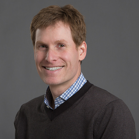 corey goldstein posed in front of gray background