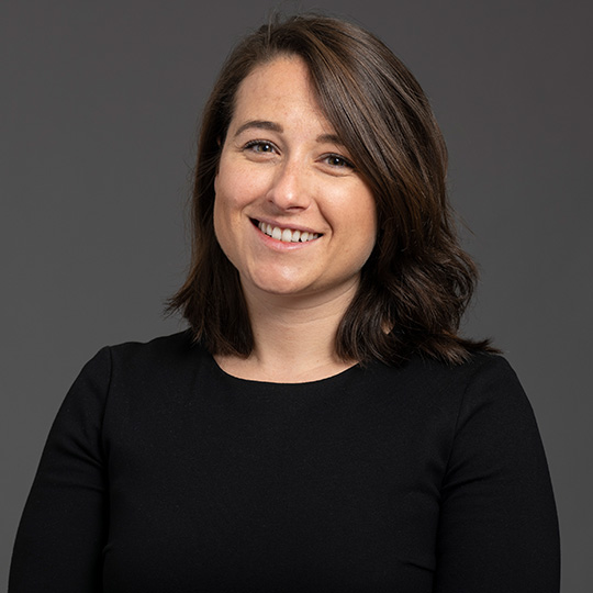 gillian alex posed in front of a gray background