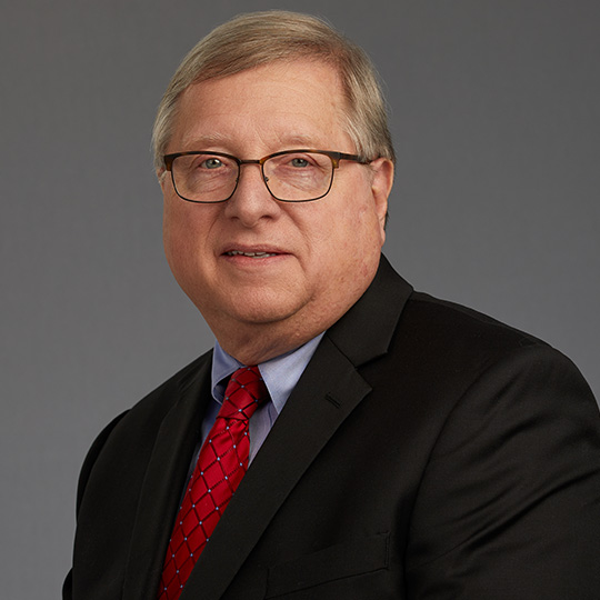 john rinehart posed in front of a gray background