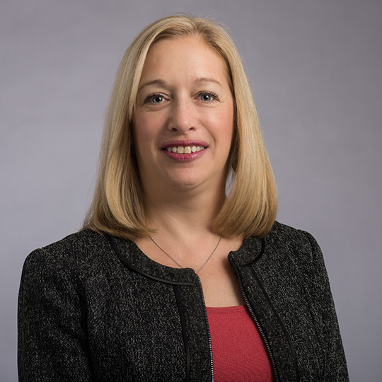 julie schneider posed in front of a gray background