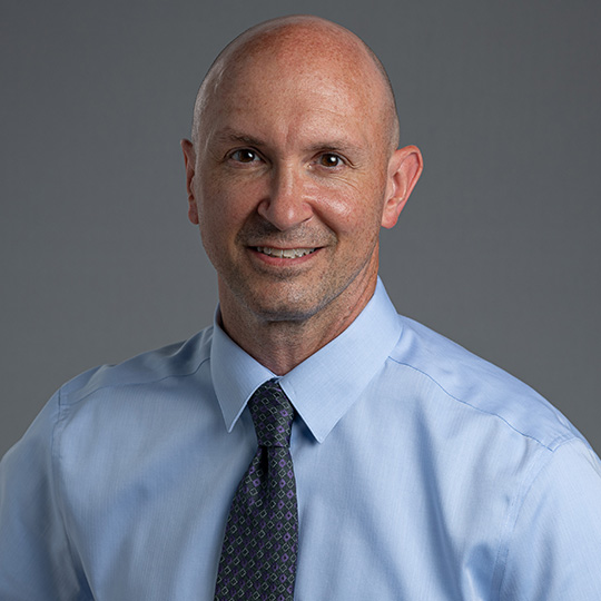 mark yoder posed in front of a gray background