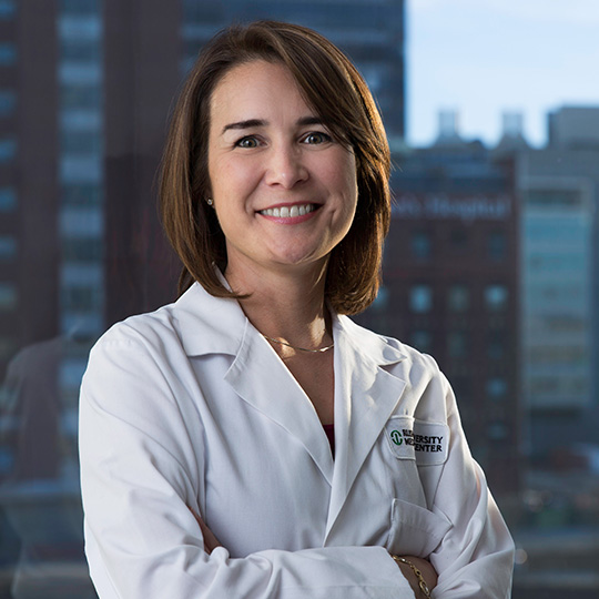 naomi parrella wearing her white coat in front of a portion of the chicago skyline