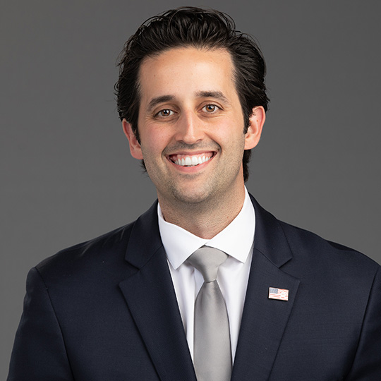 nicholas cozzi posed in front of a gray background