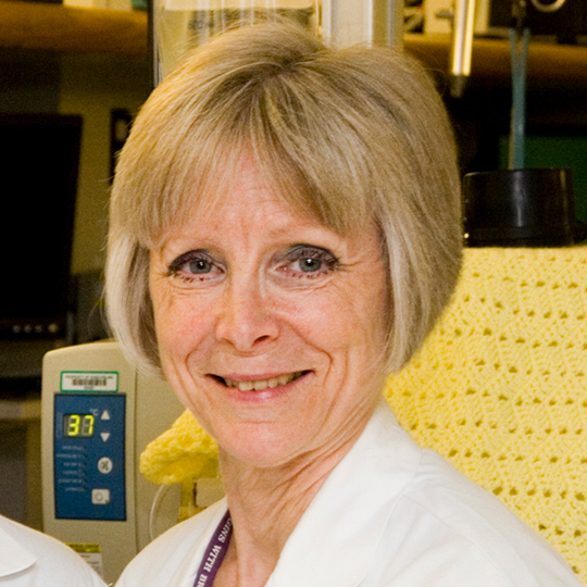 paula meier wearing a white coat posed in front of a medical device