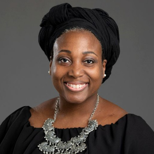 princess currence posed in front of a gray background