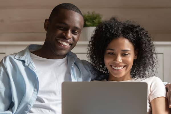 A man and woman looking at a laptop screen