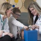 Two female doctors play with a young male patient