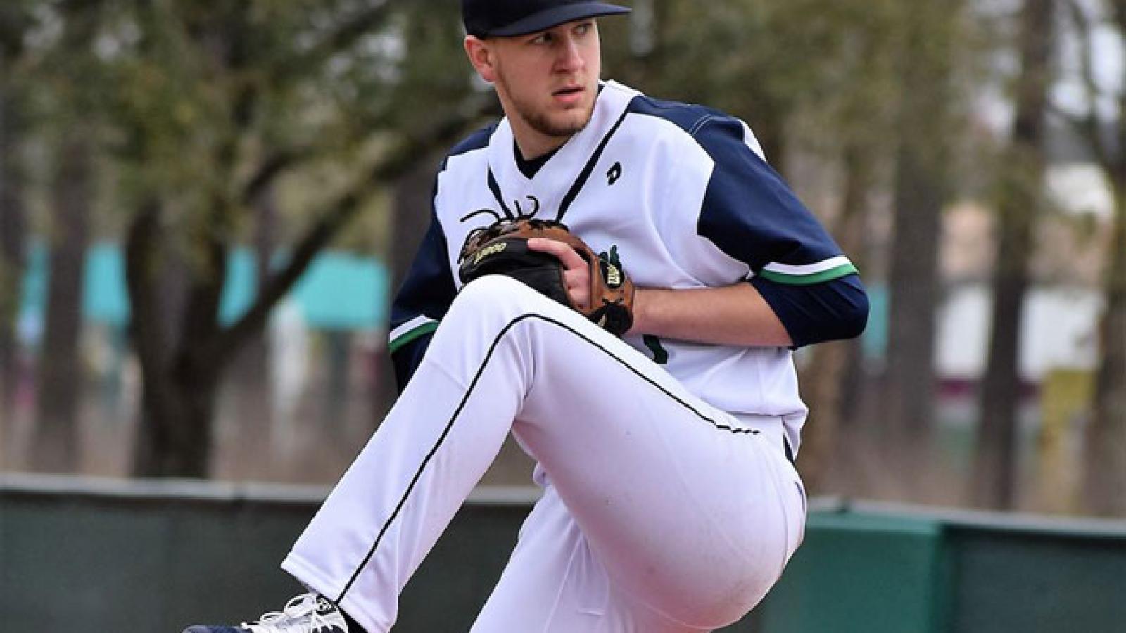 Young man in baseball uniform getting ready to pitch a ball. 
