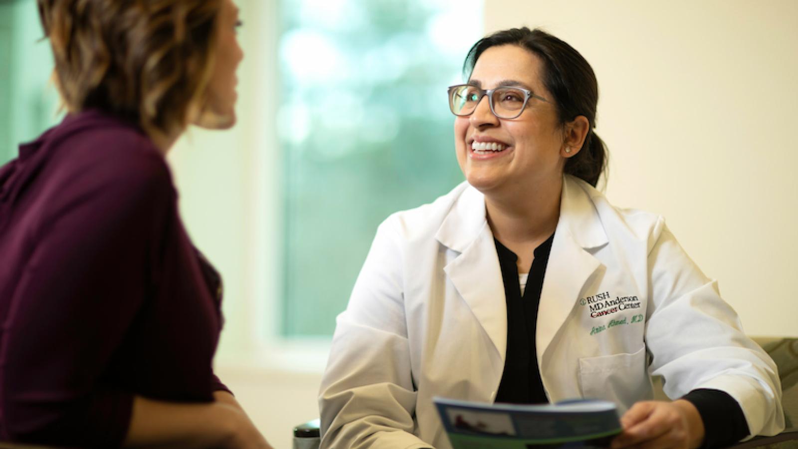 Dr. Amina Ahmed smiles while talking to another person.