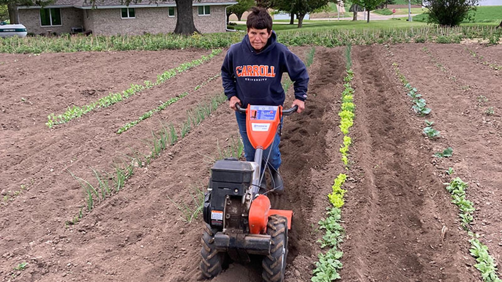 Diane tills the soil in her garden