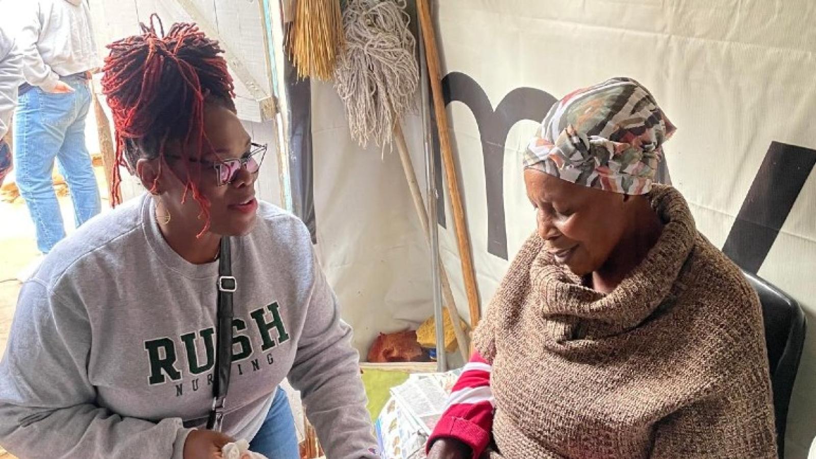 Aisha Ealey, DNP, APRN, cares for women and babies across the world. She is wearing a gray Rush University College of Nursing crewneck.