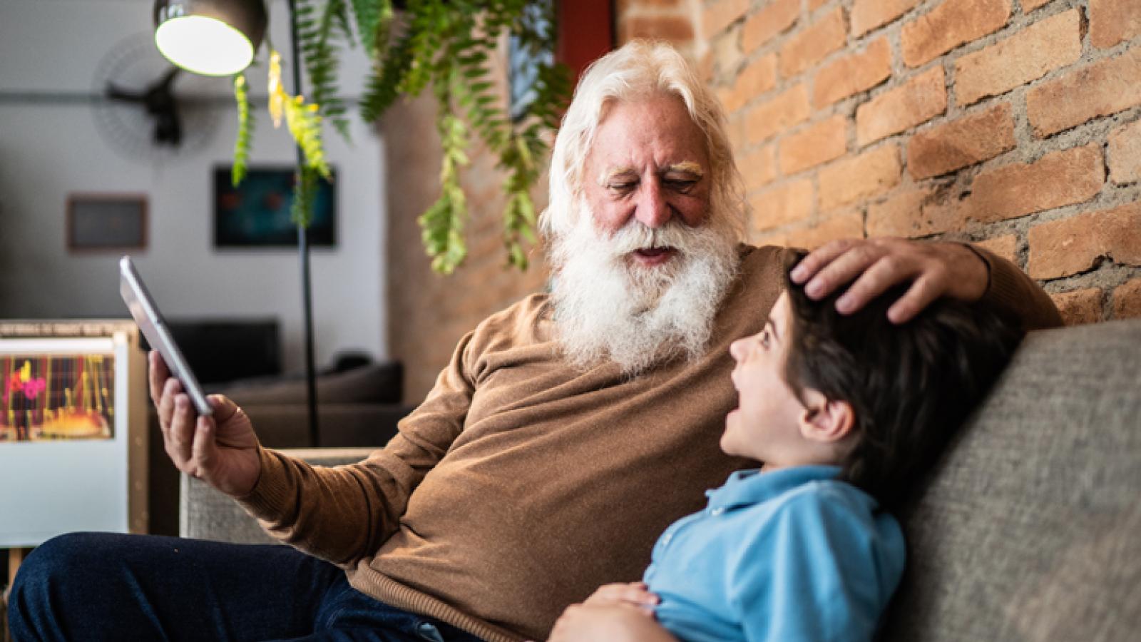 Senior man laughing with grandson while ruffling his hair