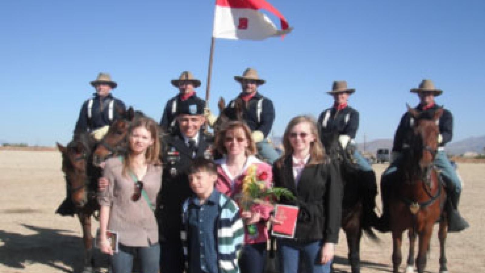 Ray Prieto from Rush Road Home Program with wife, three kids and battalion behind him.