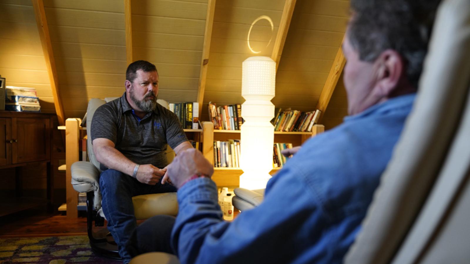 Reg McCutcheon, a trained trauma therapist, speaks with a client at his practice
