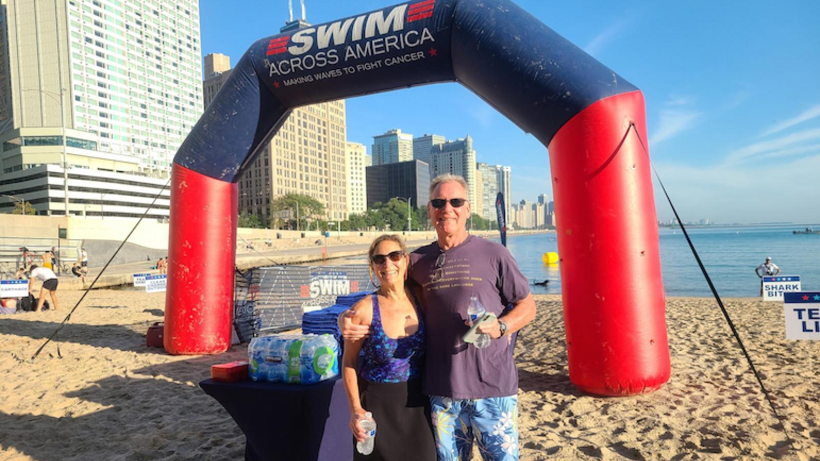 Tom Boucher and Melinda Remaly stand on Ohio Street Beach for a previous Swim Across America Chicago Open Water Swim.