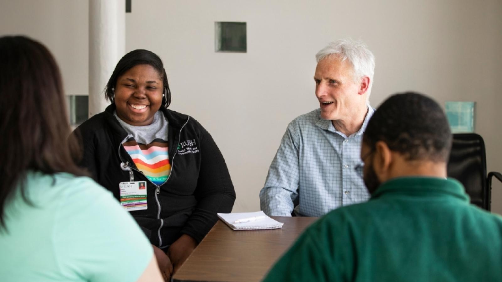 People smiling around a table in an office setting 