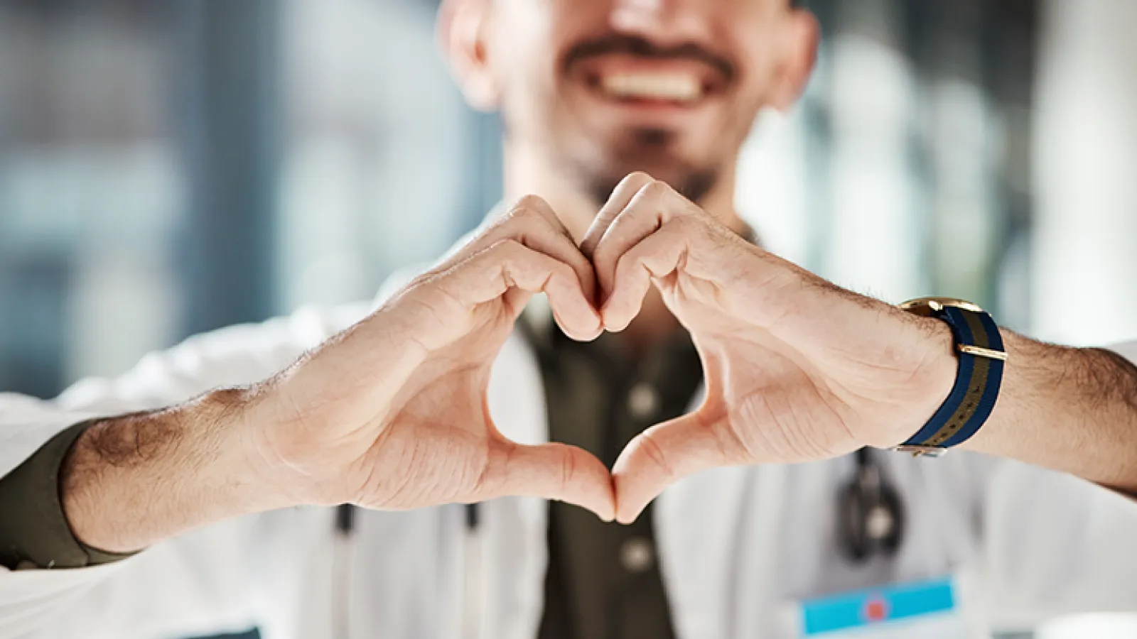 A doctor holds up hands in the shape of a heart