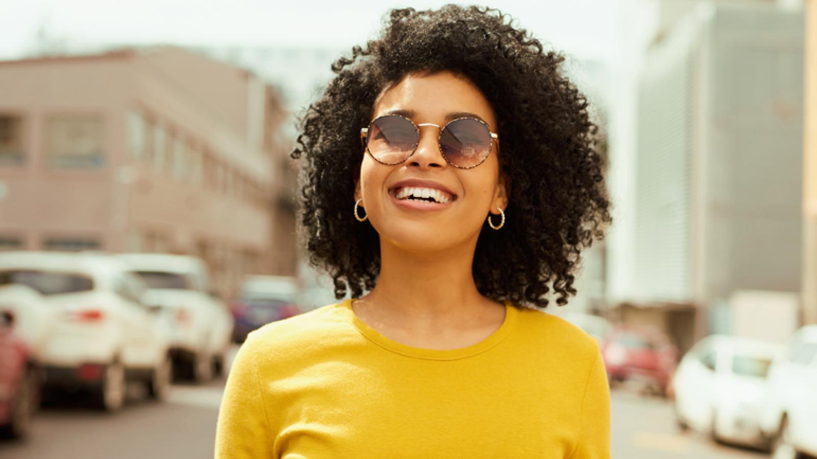 Black woman smiling and wearing sunglasses