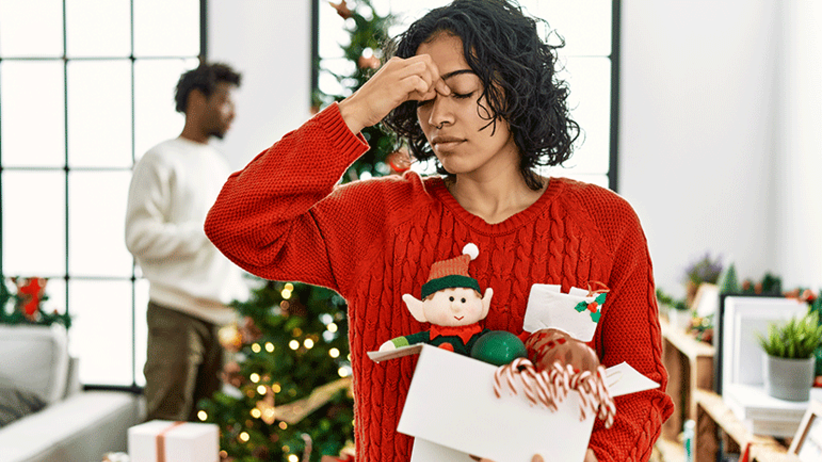 A woman feeling sick while decorating for the holidays