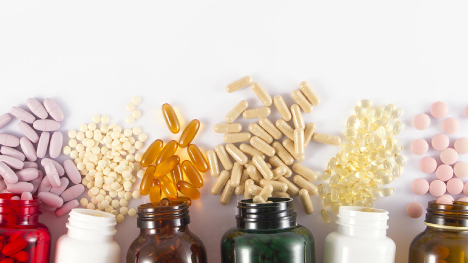 Bottles with different colored pills spilling out