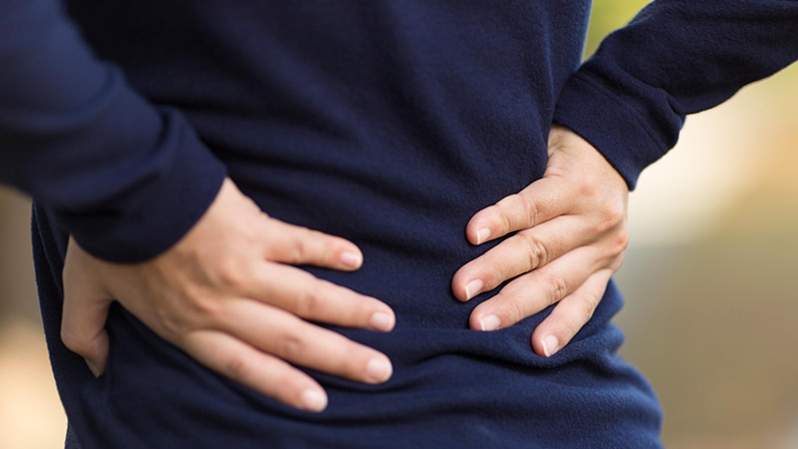 Person holding back in pain