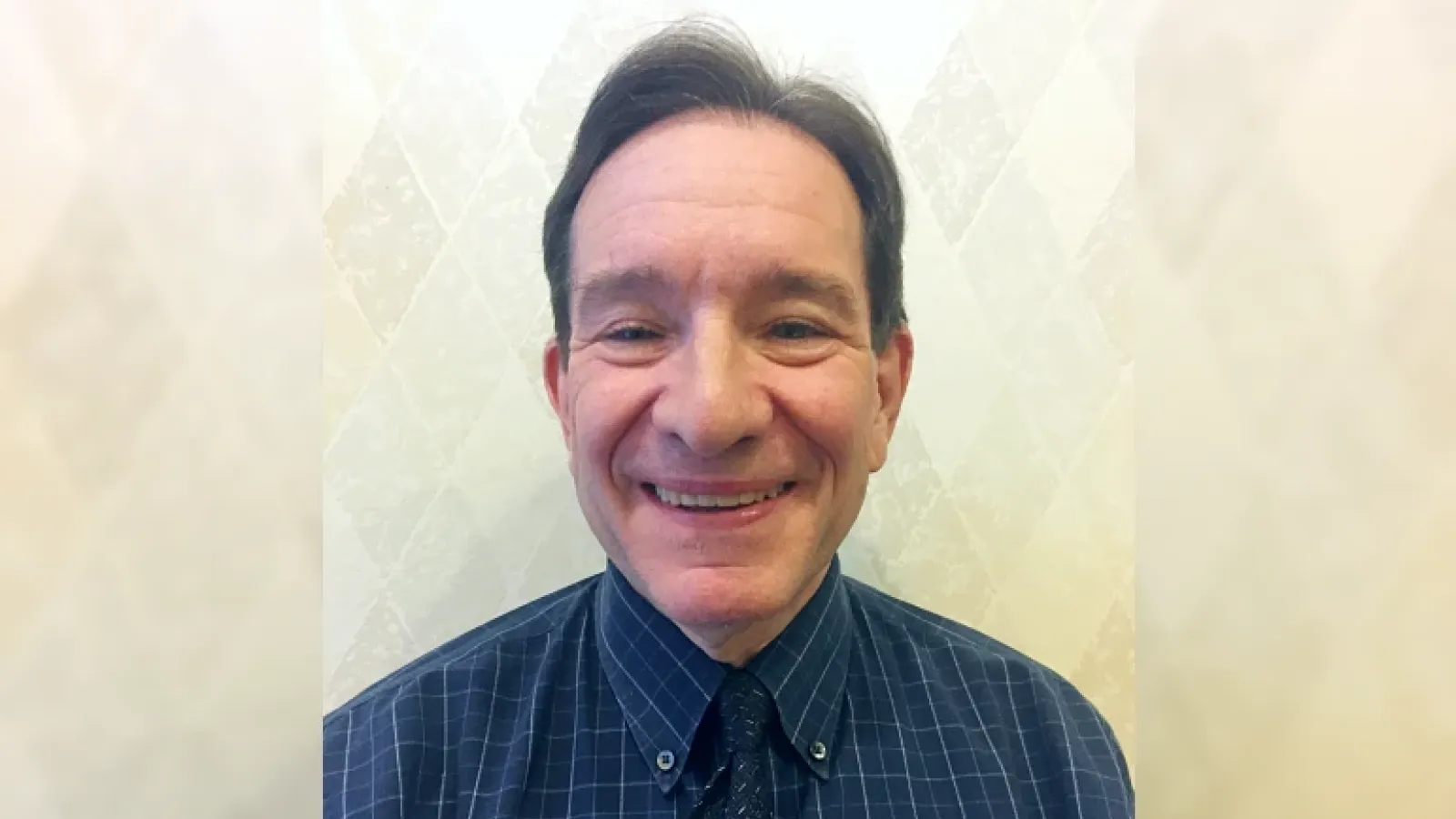 Head shot of David Margolin wearing a blue shirt and tie