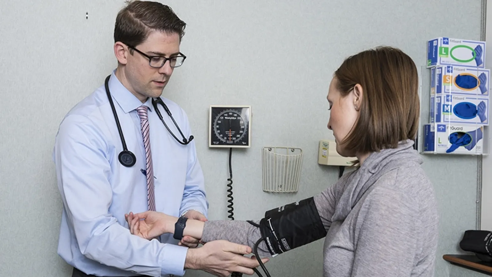 Michael Hanak, MD, taking patient blood pressure