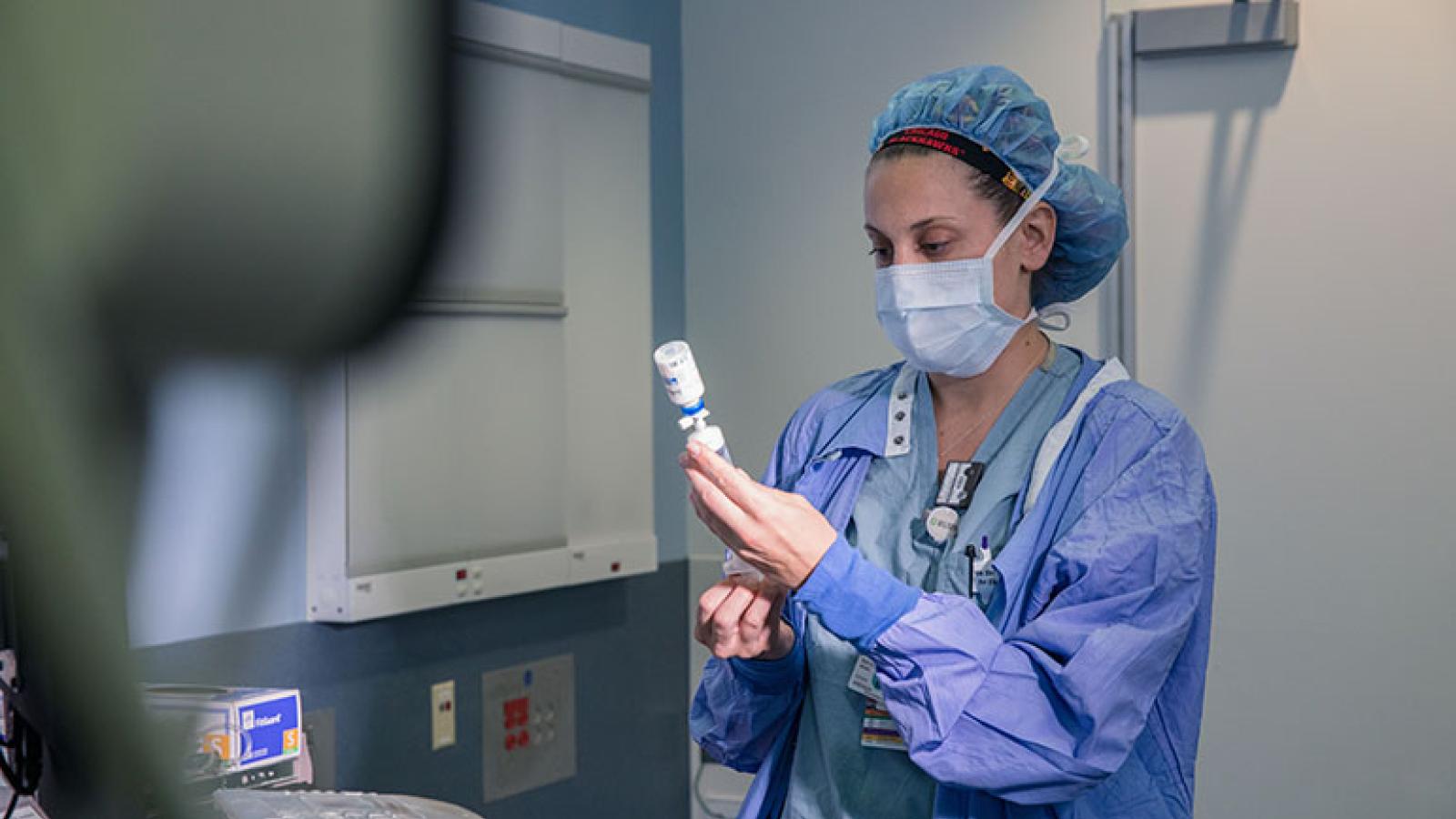 A nurse examines a medication before it's used