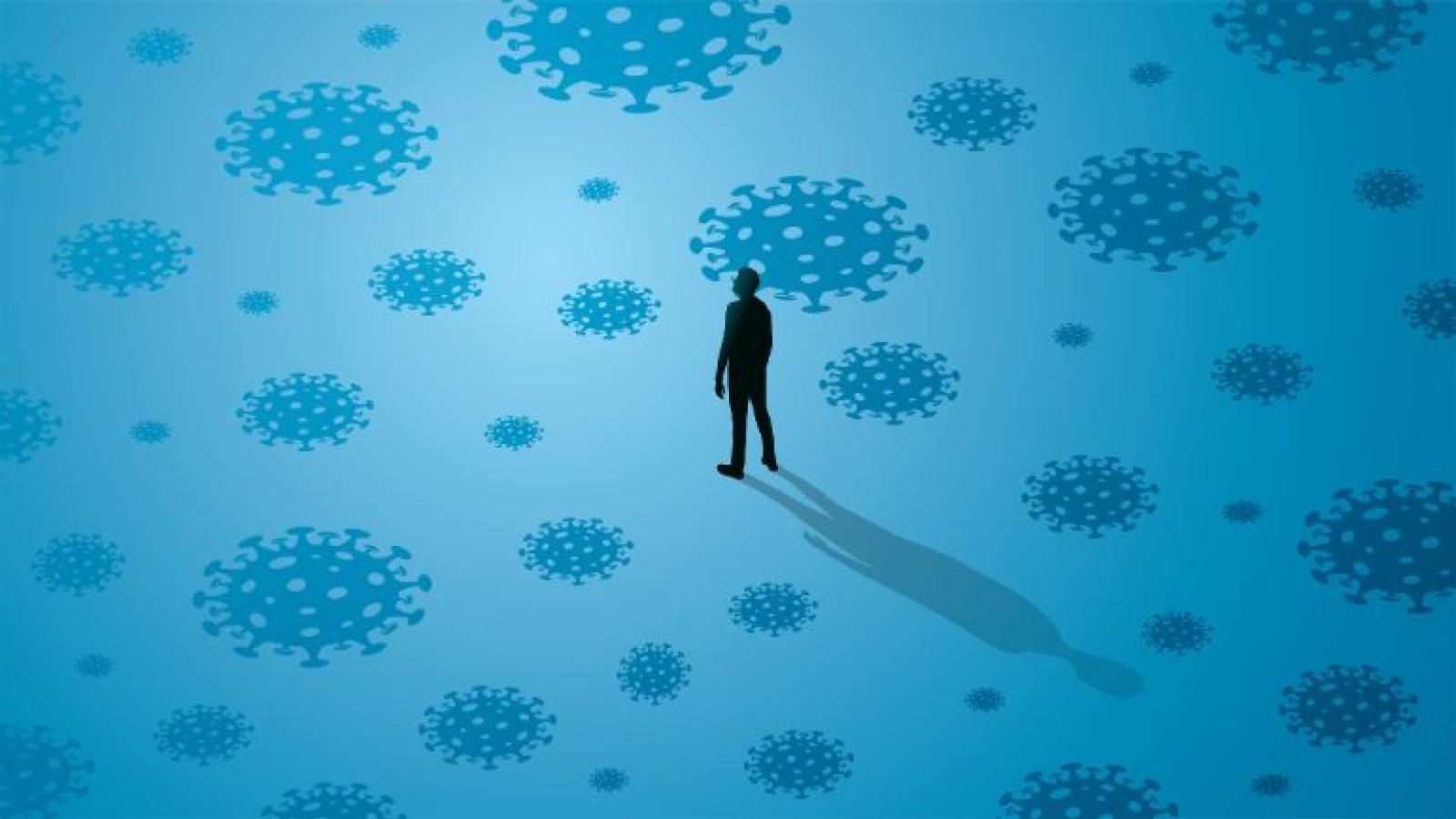 Silhouette of a person standing among large illustrations of viruses on a blue background.