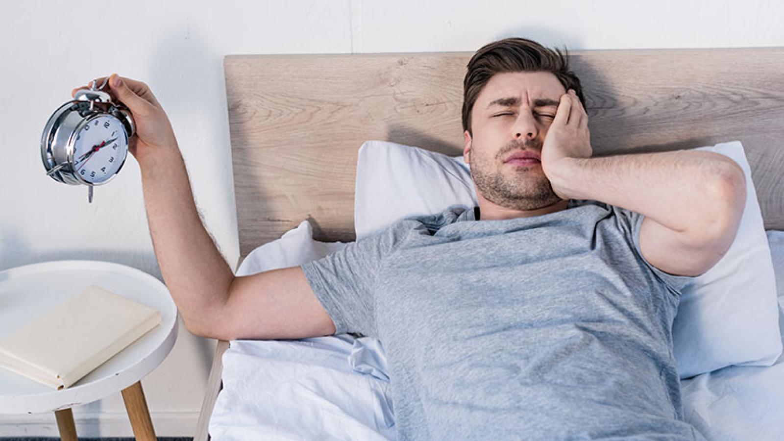 Man waking to alarm clock