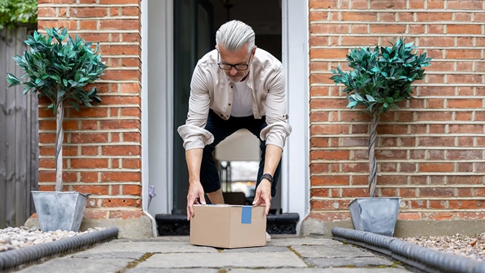 Man picking up box at doorstep