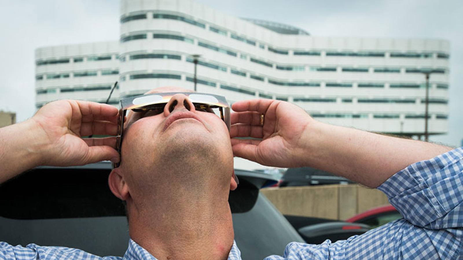 Man staring at eclipse with special glasses