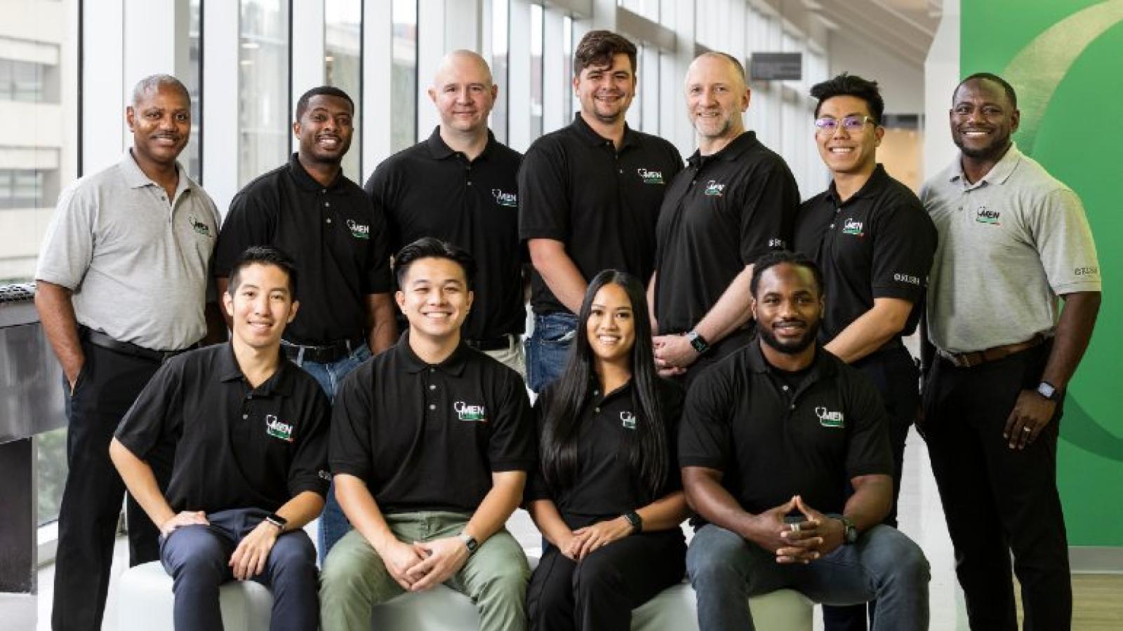 A group of students and faculty wearing shirts with Men in Nursing logos