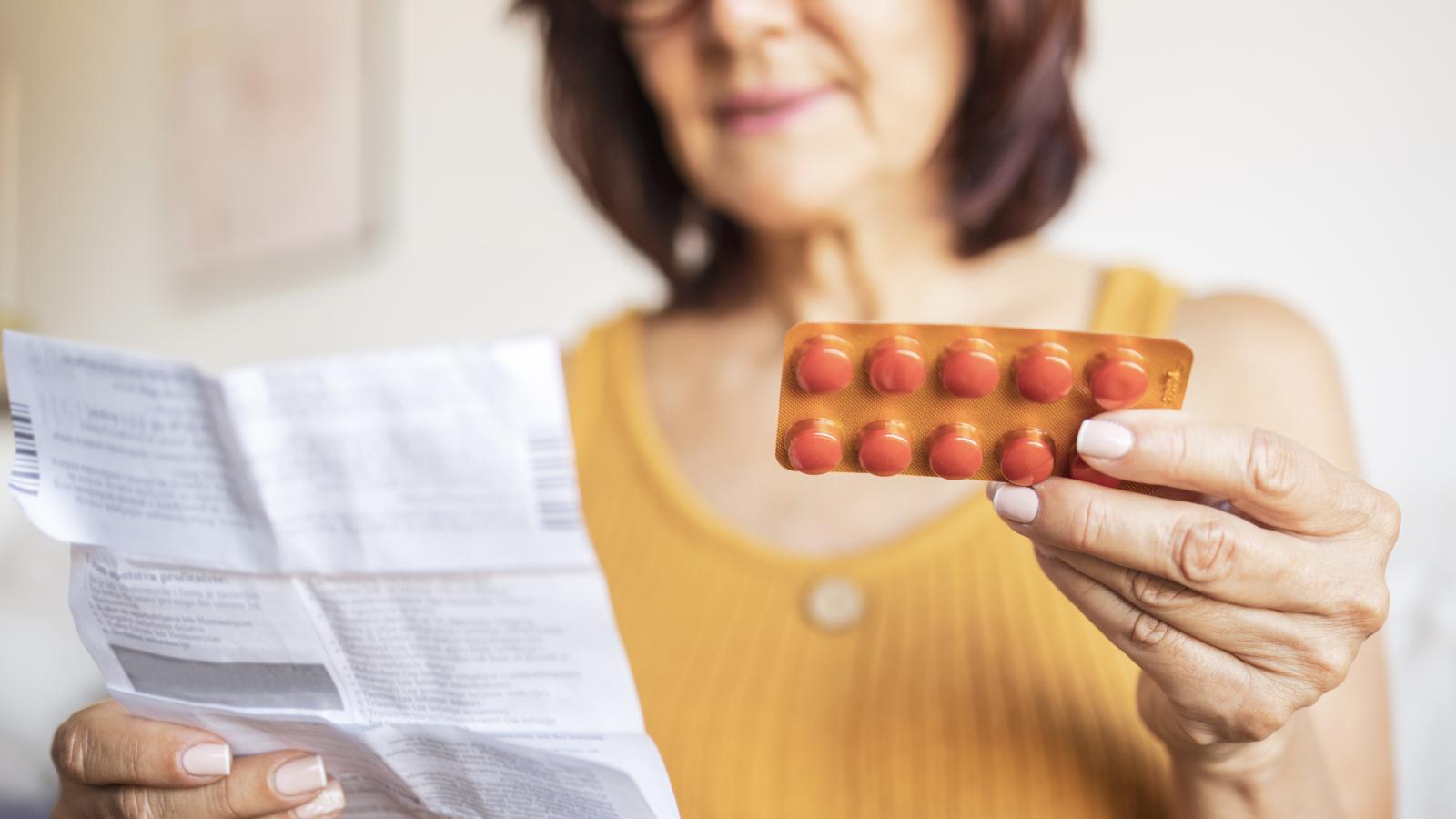 Woman holding medicine and directions