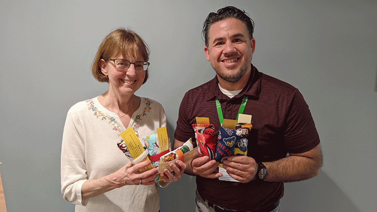 Teacher Nancy Jansen shows Omar Ramos some of the port pillows her students made.
