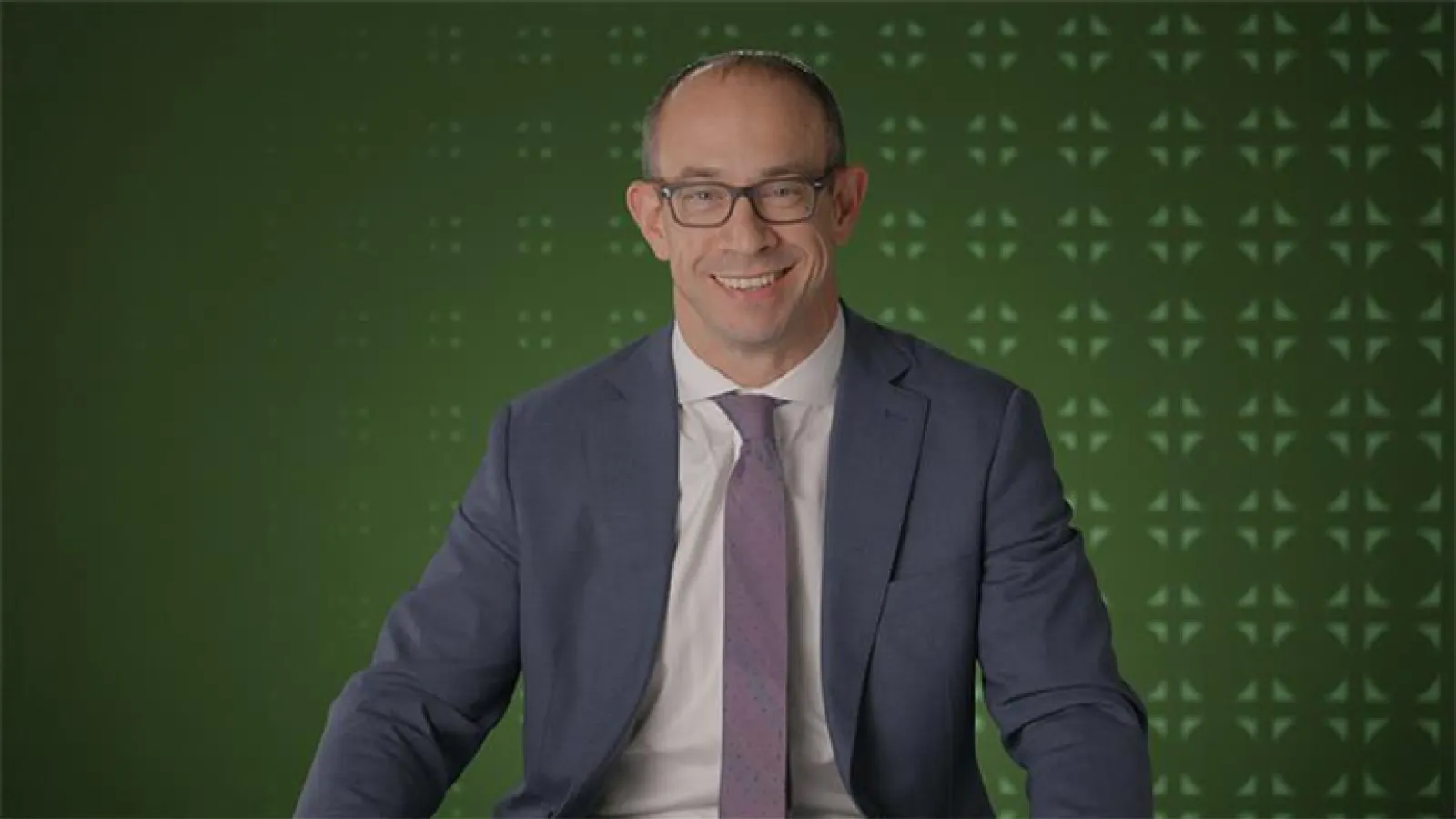 Chris seder posed in front of a green wall