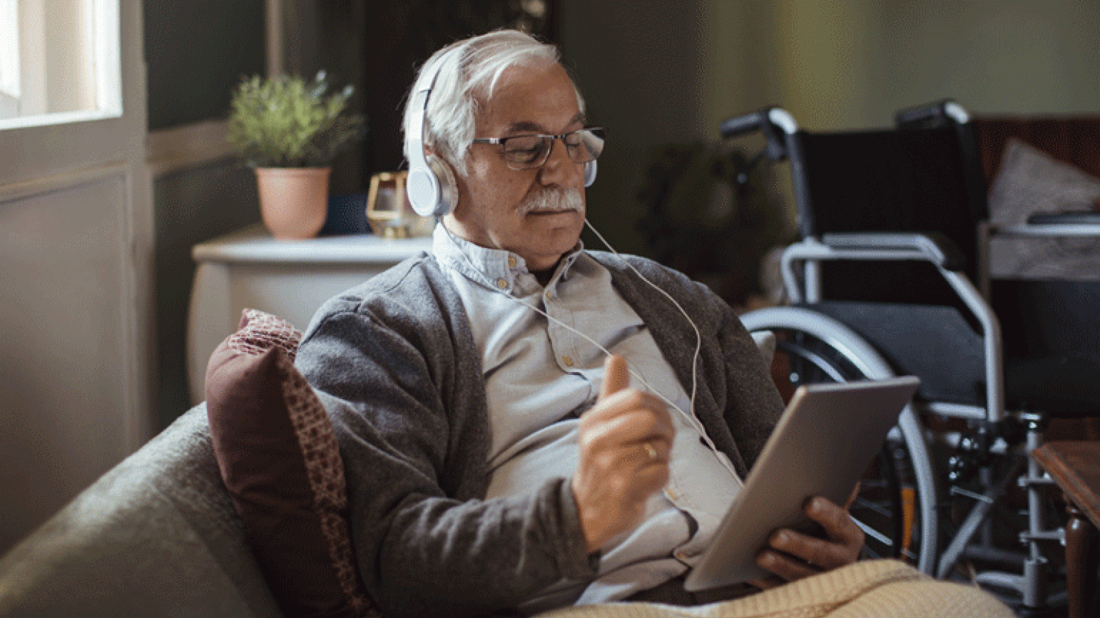 Senior Man Sitting on Living Room On Tablet