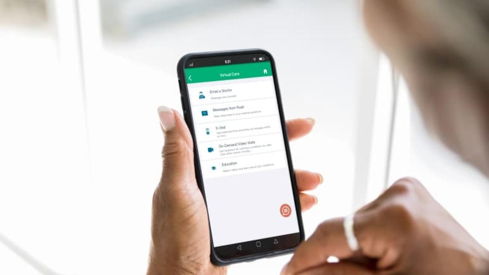 A woman using a cell phone to access Rush virtual care options.