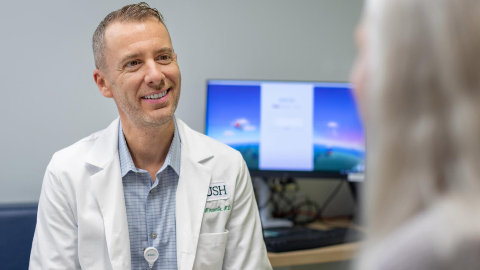 Augusto Miravalle, MD, meets with a patient.