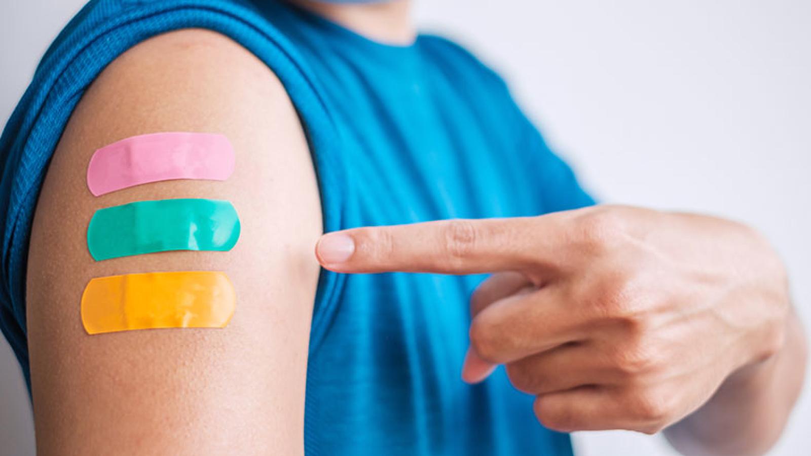 Man points to three bandages on arm