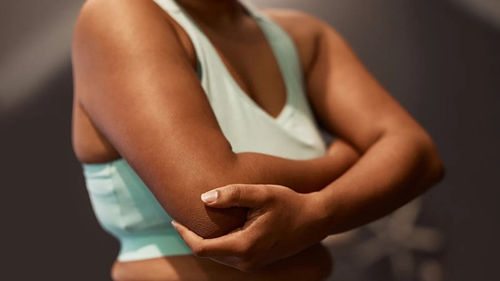 Woman in light green tank with arms crossed