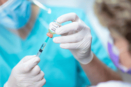 Nurse hold COVID vaccine vial