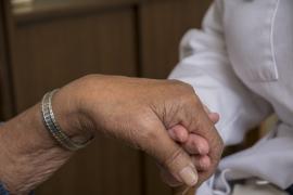 Chaplain holds patient's hand