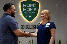 Two people shake hands inside RUSH's Road Home Program.
